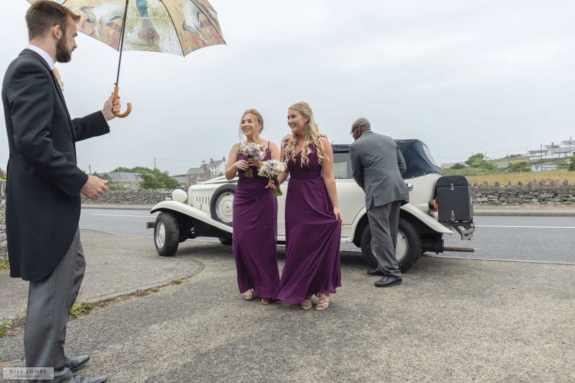 two bridesmaids are greeted by a groomsman at a Anglesey wedding