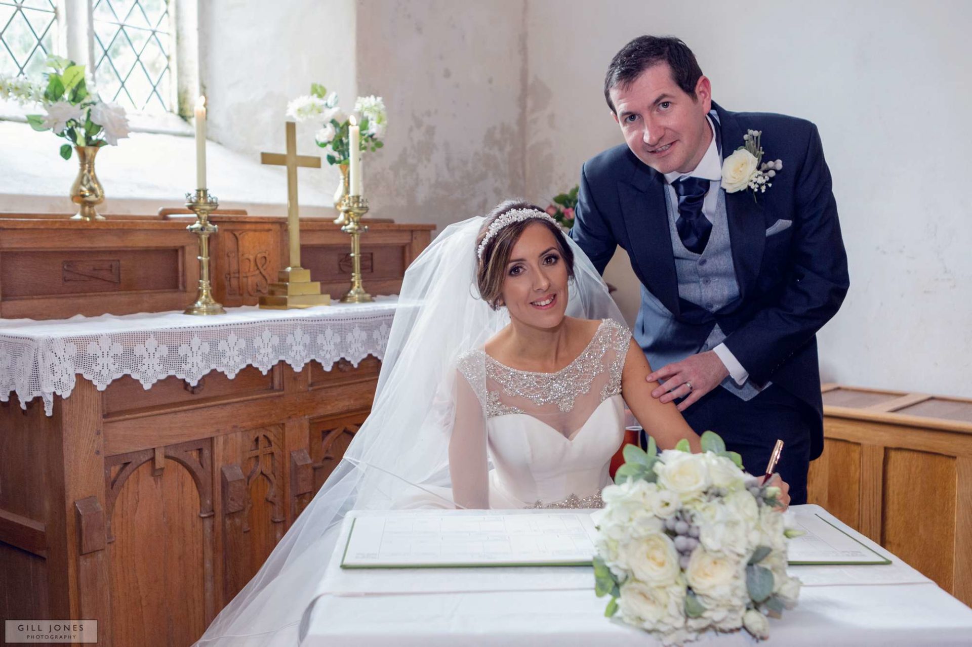 the bride and groom sign the register