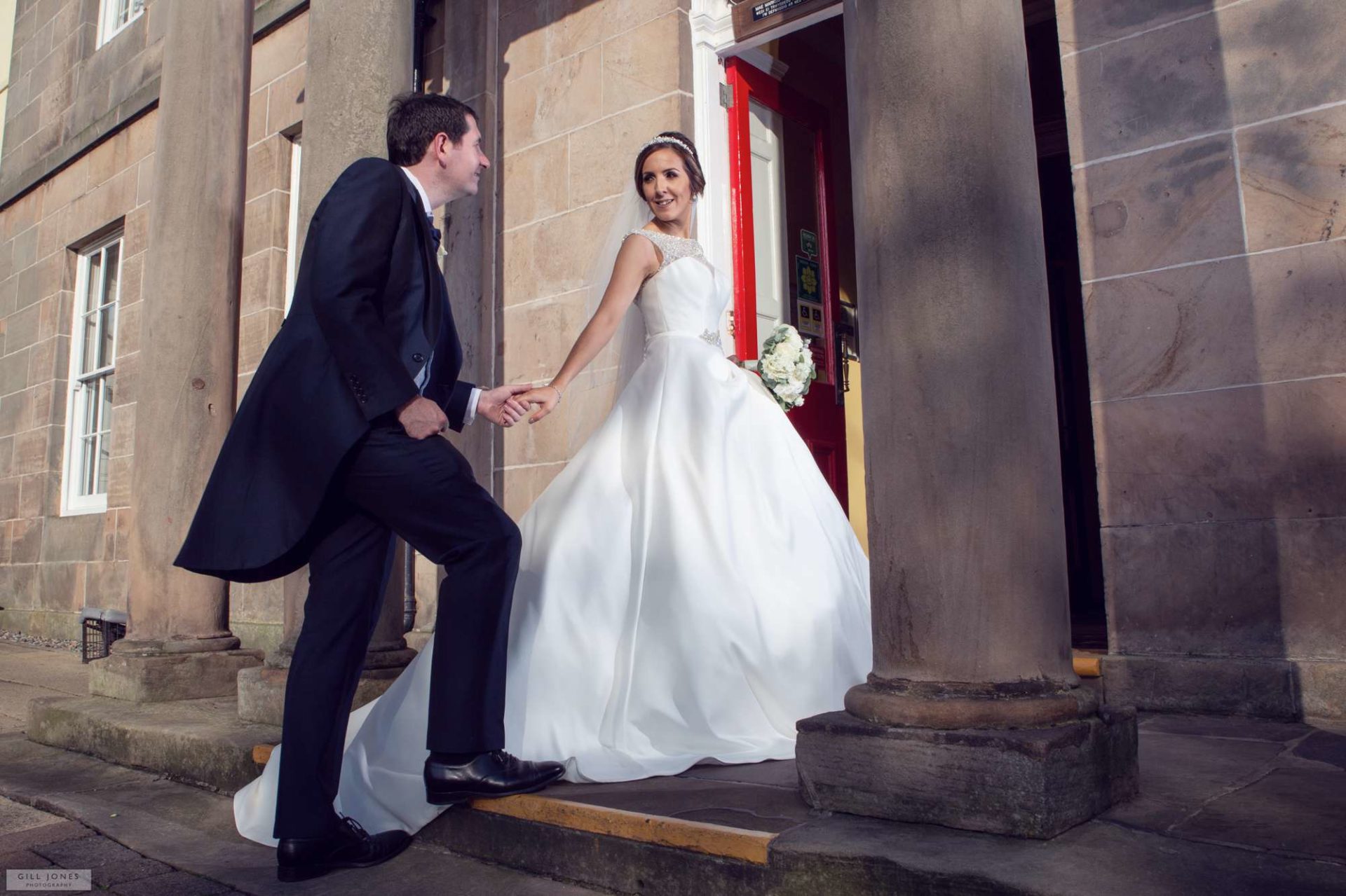 the bride and groom on the steps of the hotel