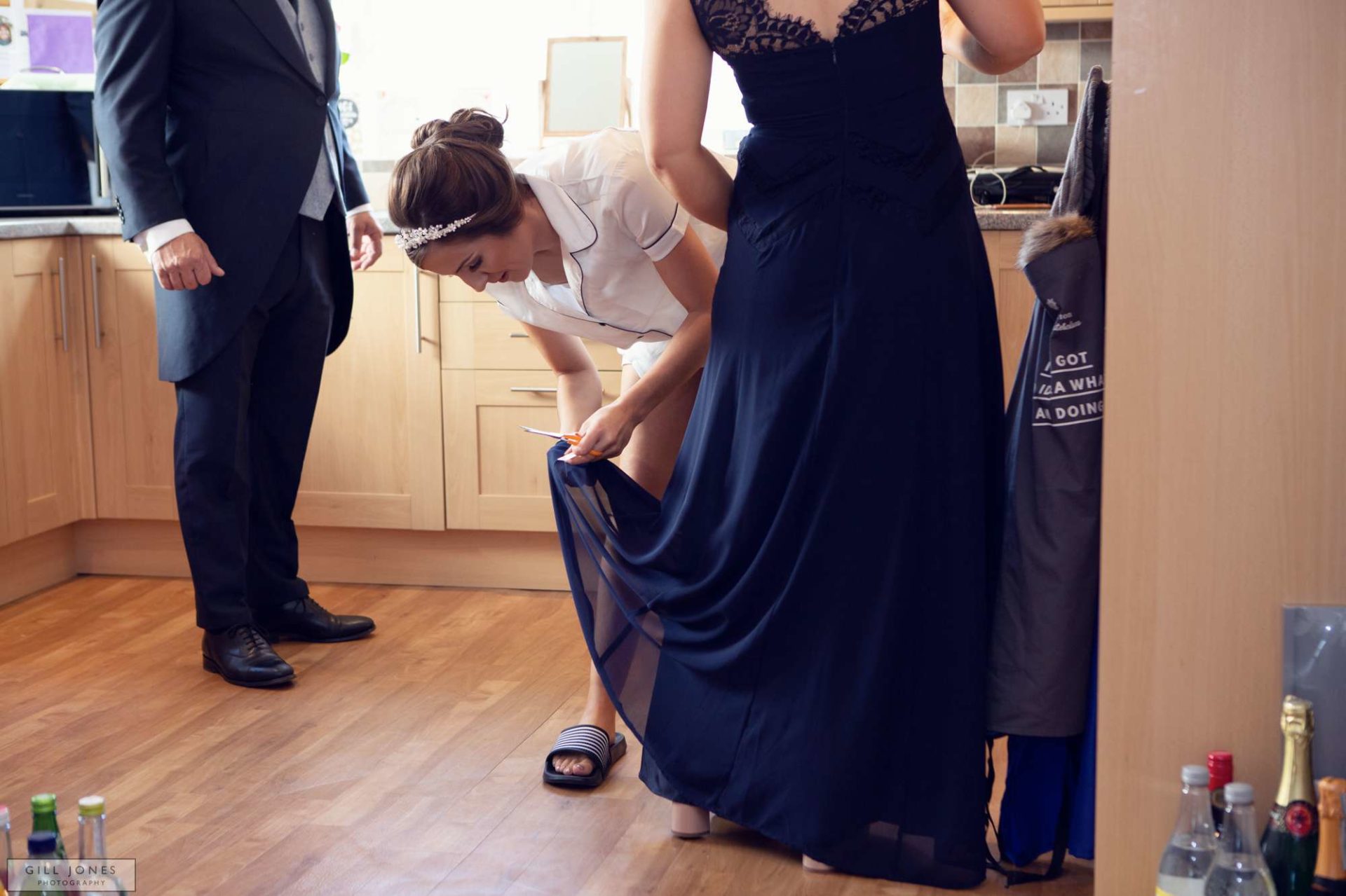 the bride cutting tags off bridesmaids dresses