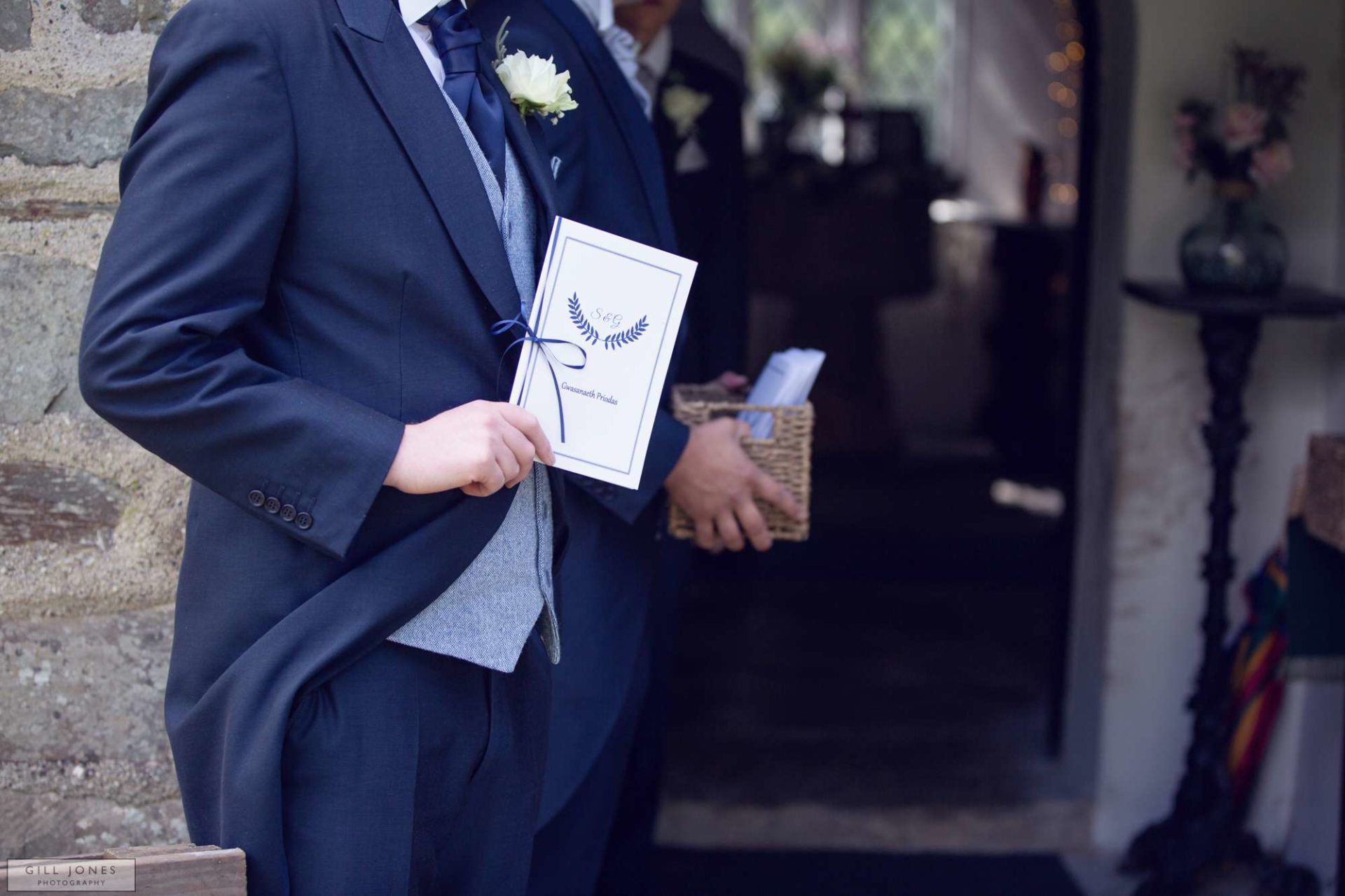 an usher holding the order of service