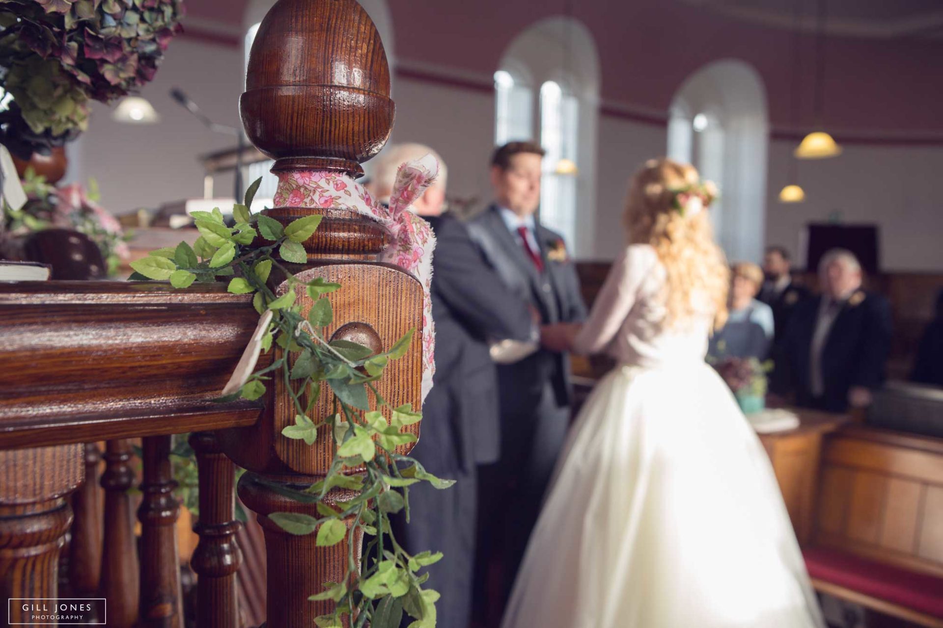 looking through flowers as the bride and groom face one another