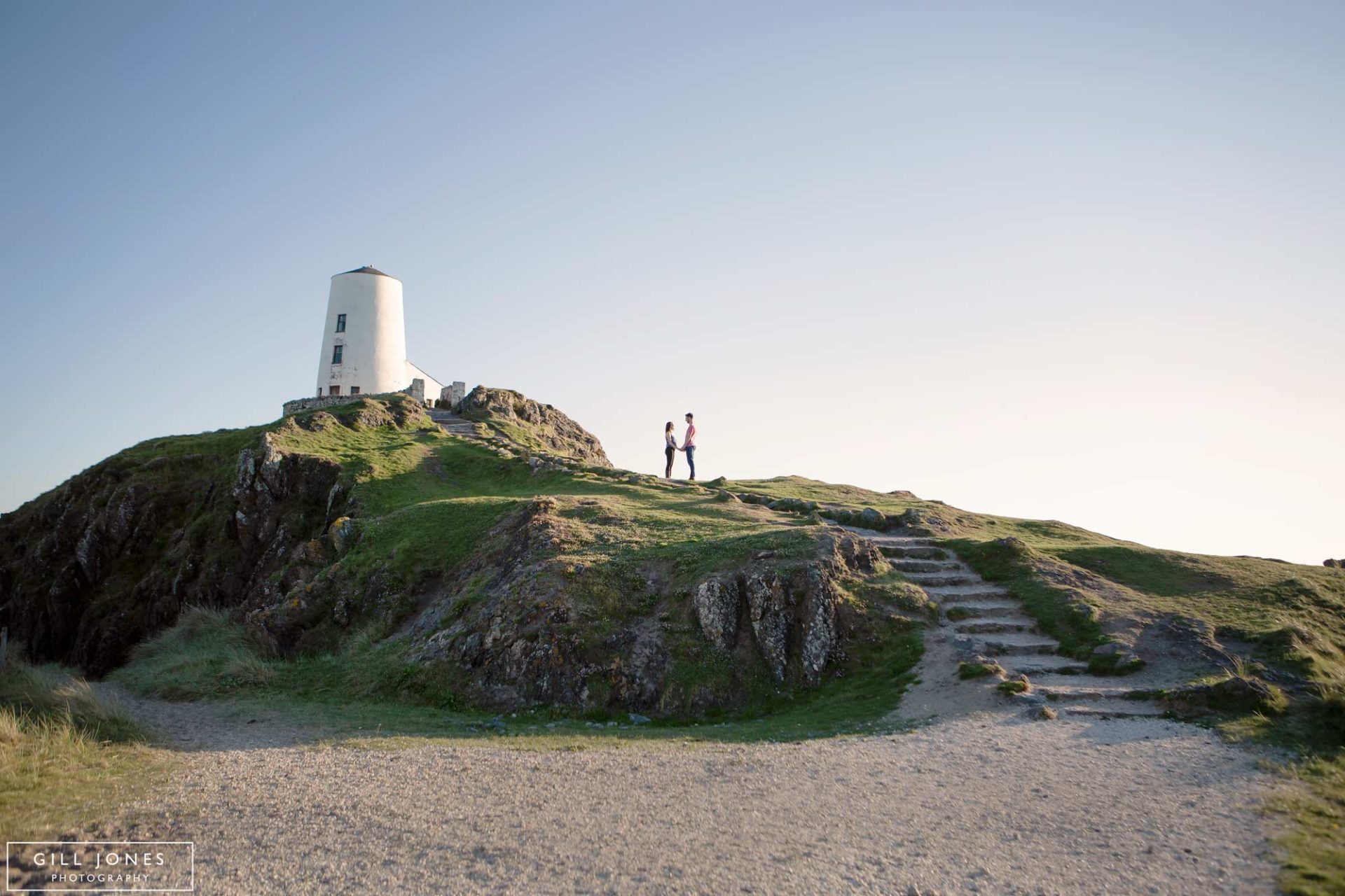 Couple silhouetted next to Llanddwyn Lighthouse