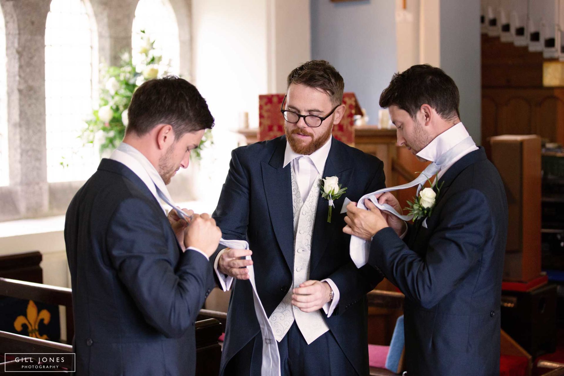 the groom tieing his tie