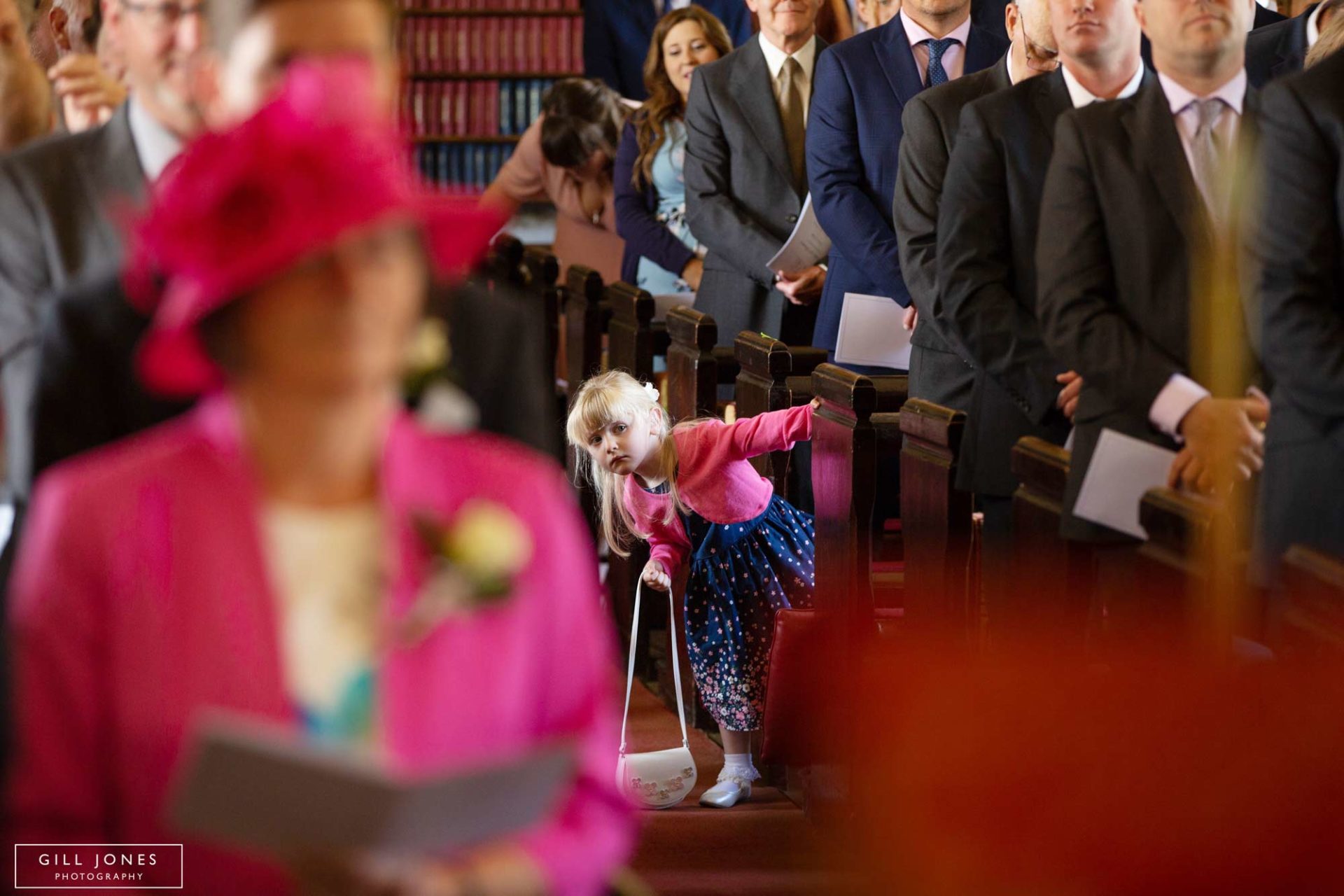 a little girl popping out of the pews
