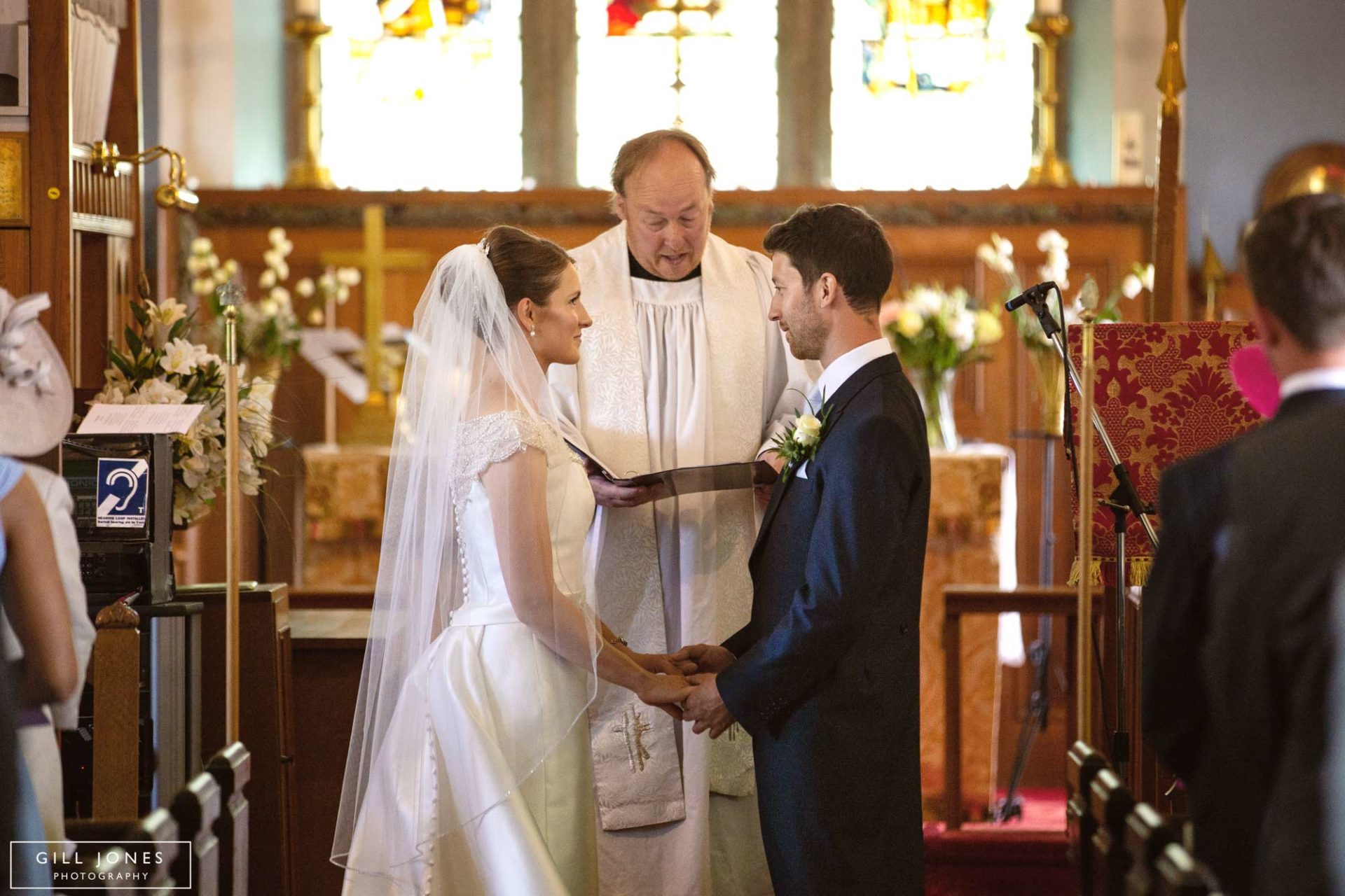 the bride and groom facing each other at the altar