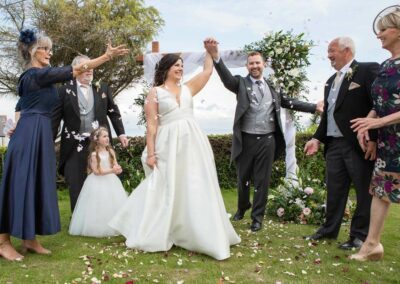 confetti is thrown at the bride and groom by their parents by Anglesey photographer Gill Jones Photography