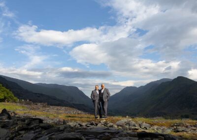 two men stand side by side with Snowdonia in the background by Anglesey wedding photographer Gill Jones Photography