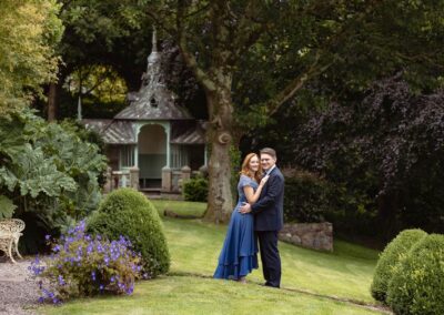 a man and woman stand with their arms around eachother, they're in a beautiful garden by Anglesey elopement photographer Gill Jones Photography