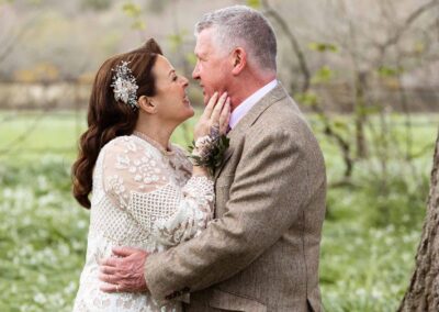 a mature bride caresses her groom's chin as they chat by Anglesey photographer Gill Jones Photography