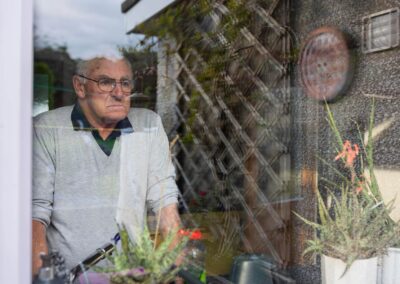 a man stares out of the kitchen window looking sad by Anglesey commercial photographer Gill Jones photography