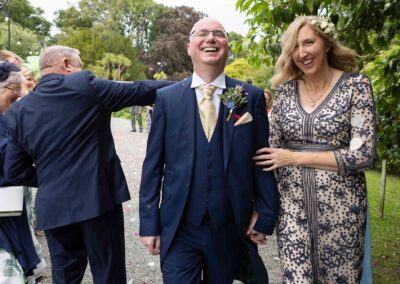 a bride and groom finish walking through confetti and smile with relief