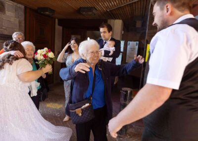 an elderly lady reaches for a hug from a groom