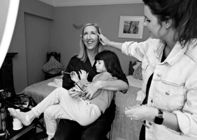 a mother hugs her daughter whilst makeup is being applied to her face