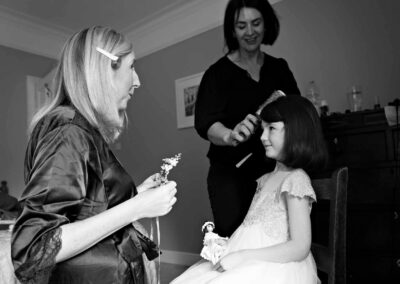 a mother waits to place a hair slide on her daughter's head