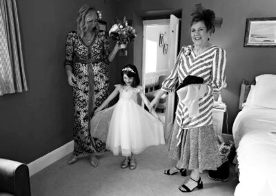 a young girl is delighted with her dress and looks at her reflection, her mother and granny look on