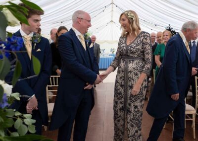 a bride greets her husband to be with a gently hand hold