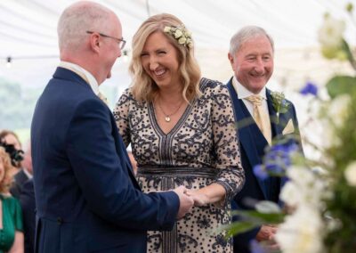 a bride faces her husband to be at the alter and smiles broadly