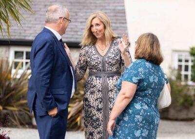 a woman chat whilst using her hands to illustrate what she's expressing to a man and a woman