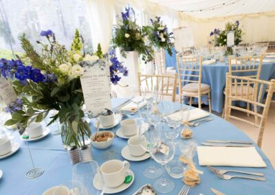 dining tables with blue table cloths with flowers and glassware