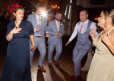 five people dance enthusiastically a spot light shines behind them